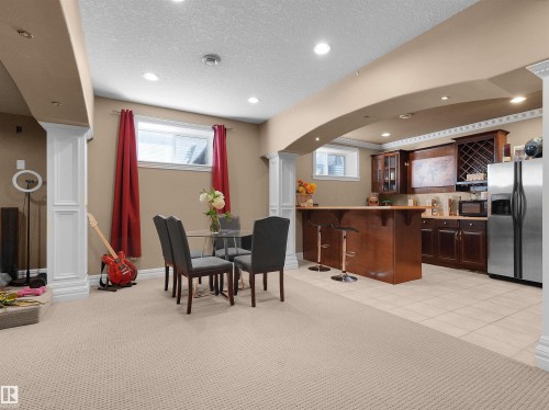 Lower-level recreation space featuring recessed lighting and a built-in wet bar with dark wood cabinetry - 1511 69 Street, Edmonton, AB - Indoor