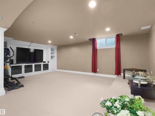 Spacious room featuring a built-in media center with shelving and storage, recessed lighting, and soft carpet flooring - 1511 69 Street, Edmonton, AB - Indoor
