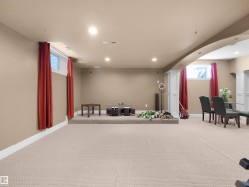 Expansive carpeted area with recessed lighting and neutral wall tones - 