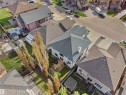 Fenced backyard featuring a multi-level wood deck, a patio area, mature trees, and an adjacent greenhouse structure - 1511 69 Street, Edmonton, AB  - Outdoor With View 