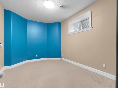 Interior room featuring a window with white trim, neutral-toned carpeting, and a ceiling-mounted light fixture - 1511 69 Street, Edmonton, AB - Indoor Photo Showing Other Room