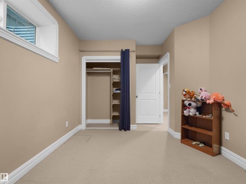 Neutral-toned room featuring a single window, a built-in closet with shelving and hanging rod, light-colored carpeting, and white baseboards - 1511 69 Street, Edmonton, AB - Indoor Photo Showing Other Room