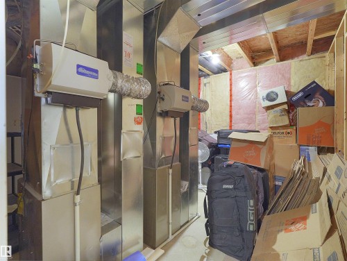 Utility area featuring two humidifiers connected to ductwork, exposed insulation on walls, and unfinished ceiling joists - 1511 69 Street, Edmonton, AB - Indoor Photo Showing Basement