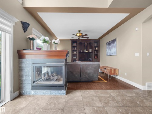 Fireplace featuring a rich wood-finish mantel and stacked stone surround - 1511 69 Street, Edmonton, AB - Indoor With Fireplace