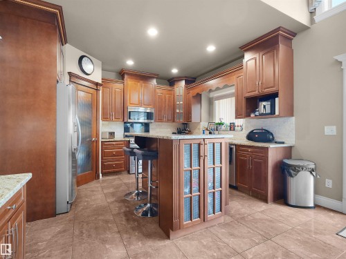 Well-appointed kitchen featuring extensive wood cabinetry, granite countertops, and tile flooring - 1511 69 Street, Edmonton, AB - Indoor Photo Showing Kitchen