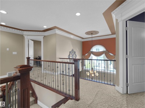 Upper-level landing featuring decorative railing, a large arched window, and recessed lighting - 1511 69 Street, Edmonton, AB - Indoor Photo Showing Other Room