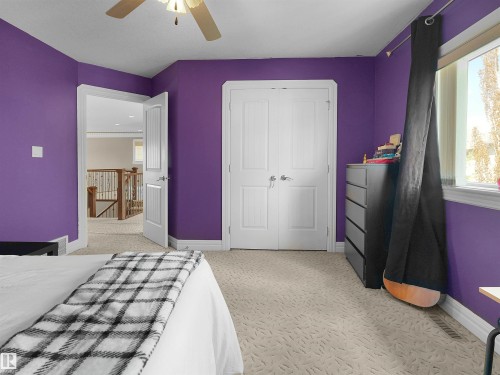 Carpeted interior with a ceiling fan, white bi-fold closet doors, and white trim - 1511 69 Street, Edmonton, AB - Indoor Photo Showing Bedroom