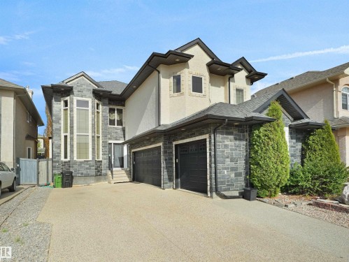 Modern stucco and stone facade featuring a multi-car garage, prominent bay window, and gabled roofline - 1511 69 Street, Edmonton, AB - Outdoor With Facade