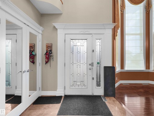 Grand entryway featuring a decorative glass front door with sidelights, complemented by ornate white trim - 1511 69 Street, Edmonton, AB - Indoor Photo Showing Other Room