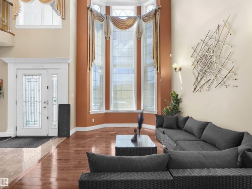 Grand foyer with double-height ceilings, a prominent bay window, and a decorative transom window - 1511 69 Street, Edmonton, AB - Indoor Photo Showing Other Room