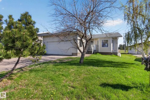 Single-story residence featuring white siding, a two-car garage, and a front porch with white railings - 5204 55 Ave, Mundare, AB - Outdoor