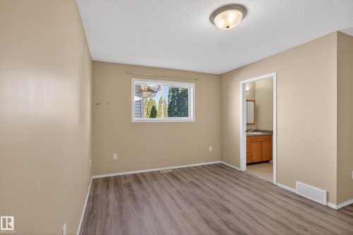 Room featuring wood-finish flooring, a window with exterior landscaping visible, a white ceiling, and a flush-mount ceiling light - 5204 55 Ave, Mundare, AB - Indoor Photo Showing Other Room
