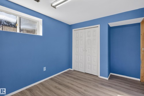 Room with wood-finish flooring and blue painted walls - 5204 55 Ave, Mundare, AB - Indoor Photo Showing Other Room
