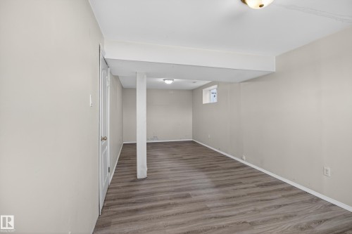 Expansive room featuring wood-finish flooring, light neutral wall paint, and recessed lighting - 5204 55 Ave, Mundare, AB - Indoor