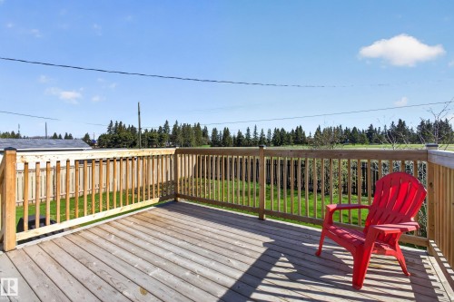 Spacious wooden deck featuring a natural wood railing, providing an outdoor living area - 5204 55 Ave, Mundare, AB - Outdoor