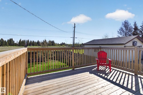 Expansive wood-finish deck with full railings, offering open-air outdoor living - 5204 55 Ave, Mundare, AB - Outdoor With Exterior