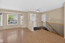 Open-concept living space featuring wood-finish flooring, a bay window with blinds, and neutral wall paint - 5204 55 Ave, Mundare, AB  - Indoor Photo Showing Other Room 