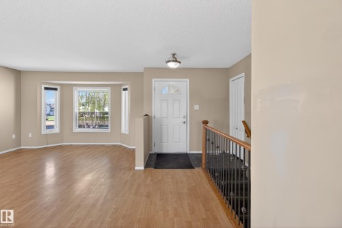 Foyer entry with wood-finish flooring, a white paneled door, and an overhead flush mount light fixture - 5204 55 Ave, Mundare, AB - Indoor Photo Showing Other Room