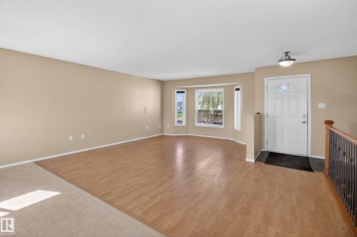 Spacious interior featuring wood-finish flooring, a bright bay window, and neutral wall tones - 5204 55 Ave, Mundare, AB - Indoor Photo Showing Other Room
