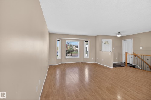 Spacious interior with wood-finish flooring, a bay window with multiple panes, and neutral wall tones - 5204 55 Ave, Mundare, AB - Indoor Photo Showing Other Room