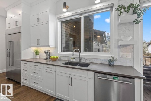 Contemporary kitchen featuring white cabinetry, dark countertops, and stainless steel appliances - 10611 146 Street Nw, Edmonton, AB - Indoor Photo Showing Kitchen With Double Sink With Upgraded Kitchen
