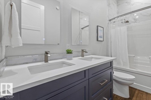 Dual vanity with integrated sinks and brushed nickel faucets, dark wood-finish cabinetry, white countertop, and tiled backsplash - 10611 146 Street Nw, Edmonton, AB - Indoor Photo Showing Bathroom