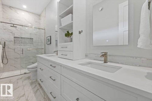 Dual vanity with integrated sinks and white cabinetry, featuring a matching countertop and tile backsplash - 10611 146 Street Nw, Edmonton, AB - Indoor Photo Showing Bathroom