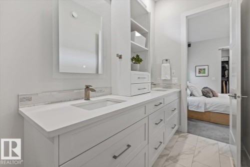 Double vanity with integrated sinks, quartz countertops, and a full-height storage cabinet - 10611 146 Street Nw, Edmonton, AB - Indoor Photo Showing Bathroom