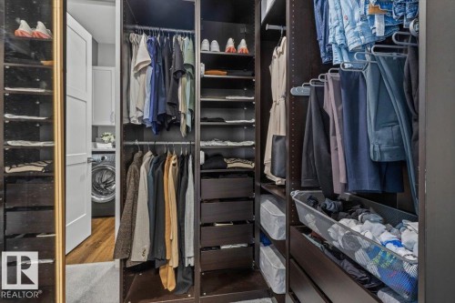 Custom closet system featuring dark wood-finish cabinetry, integrated shelving, and hanging rods - 10611 146 Street Nw, Edmonton, AB - Indoor With Storage