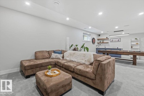 Finished basement featuring recessed lighting, a wet bar with open shelving, a built-in sink, and light gray carpeting - 10611 146 Street Nw, Edmonton, AB - Indoor