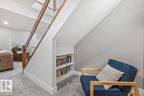 Contemporary staircase featuring glass panels and wood-finish handrails - 10611 146 Street Nw, Edmonton, AB - Indoor Photo Showing Other Room