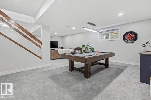 Open concept recreation room featuring light gray carpeting, recessed ceiling lighting, and a linear pendant fixture - 10611 146 Street Nw, Edmonton, AB - Indoor Photo Showing Other Room