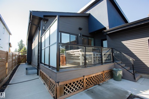Private outdoor deck with glass panel railings, composite decking, and wood lattice skirting - 10611 146 Street Nw, Edmonton, AB - Outdoor With Exterior