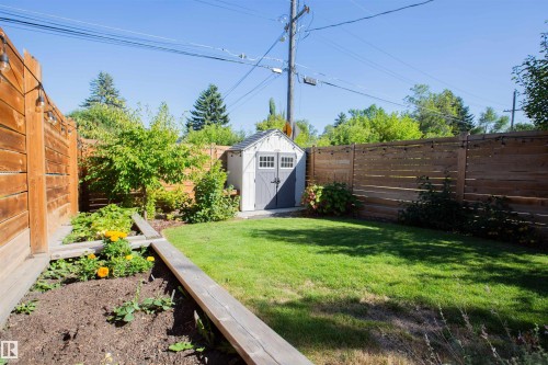 Private backyard featuring a well-maintained lawn, a freestanding storage shed, and raised garden beds - 10611 146 Street Nw, Edmonton, AB - Outdoor