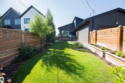 Manicured lawn with a wooden privacy fence - 10611 146 Street Nw, Edmonton, AB - Outdoor With Exterior