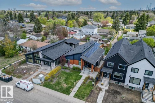Modern residential architecture featuring contrasting dark and light exteriors, angular rooflines, and a well-maintained lawn - 10611 146 Street Nw, Edmonton, AB - Outdoor