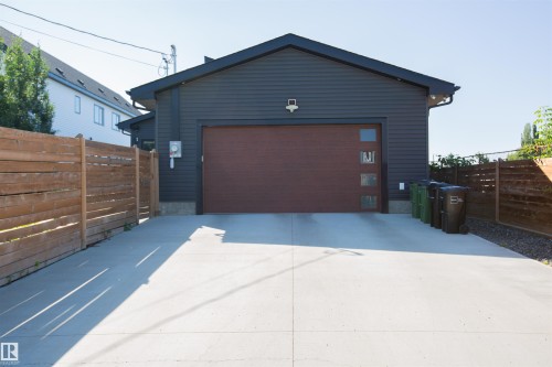 Detached structure with dark horizontal siding and a dark brown garage door featuring frosted window panels - 10611 146 Street Nw, Edmonton, AB - Outdoor With Exterior