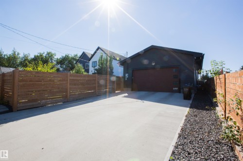 Detached garage featuring dark siding and a brown overhead door - 10611 146 Street Nw, Edmonton, AB - Outdoor