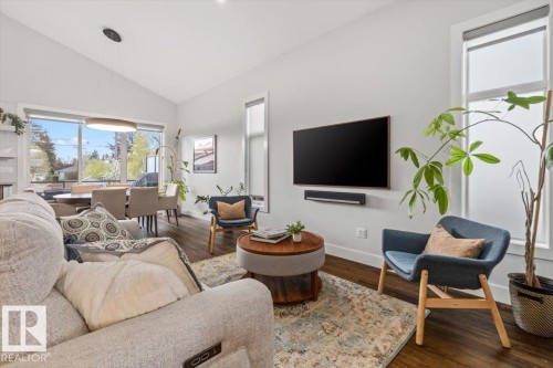 Open-concept living space featuring wood-finish flooring, a vaulted ceiling, and multiple windows - 10611 146 Street Nw, Edmonton, AB - Indoor Photo Showing Living Room