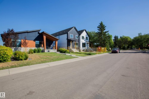 Contemporary exterior featuring a distinctive sloped roofline, a prominent wood-clad entryway, and a mix of dark paneling and warm-toned siding - 10611 146 Street Nw, Edmonton, AB - Outdoor With Facade