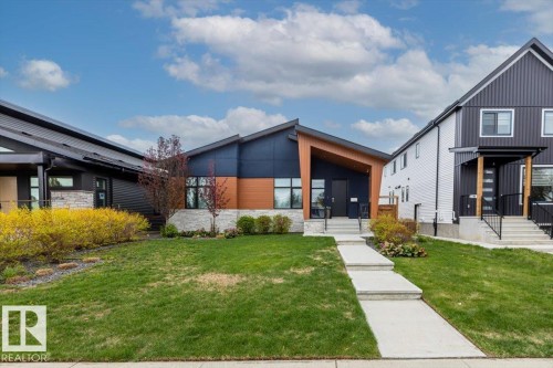 Modern architectural design featuring a dark siding facade with wood-finish accents - 10611 146 Street Nw, Edmonton, AB - Outdoor With Facade