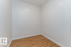 Compact room featuring light-toned walls and wood-finish flooring - 