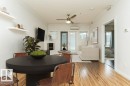 Open-concept living space with wood-finish flooring, crown molding, a built-in fireplace, and direct access to an outdoor area - 145 10121 80 Avenue, Edmonton, AB  - Indoor Photo Showing Dining Room 