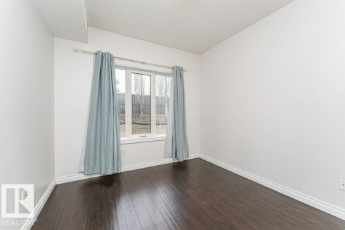 Room featuring wood-finish flooring, white baseboards, and neutral wall paint - 145 10121 80 Avenue, Edmonton, AB - Indoor Photo Showing Other Room