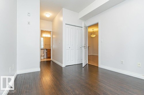 Room featuring dark wood-finish flooring, white walls, and white baseboards - 145 10121 80 Avenue, Edmonton, AB - Indoor Photo Showing Other Room
