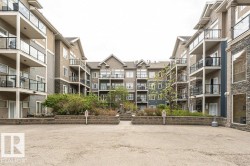 Multi-story building exterior featuring balconies with glass railings, stone veneer accents, and gabled rooflines - 
