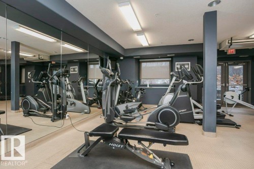 Dedicated fitness space featuring mirrored walls, recessed lighting, and a textured carpeted floor - 145 10121 80 Avenue, Edmonton, AB - Indoor Photo Showing Gym Room
