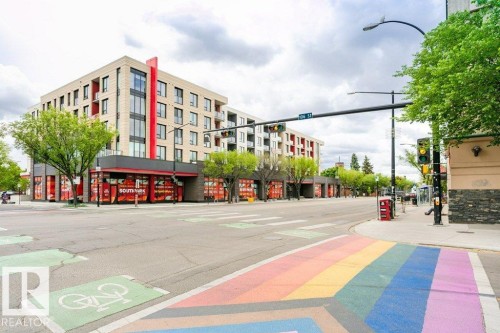 Modern mixed-use building featuring ground-floor retail space, multiple stories of residential units, and a contemporary facade with red accent panels - 145 10121 80 Avenue, Edmonton, AB - Outdoor