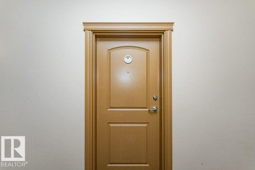 Panel door with arched upper panel and polished chrome hardware - 145 10121 80 Avenue, Edmonton, AB -  Photo Showing Other Room