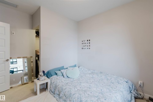 Carpeted room with neutral wall tones and a standard white door - 510 5151 Windermere Boulevard, Edmonton, AB - Indoor Photo Showing Bedroom